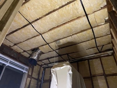 Polyester batts secured between floor joists under a raised timber floor